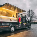 BurgerBox Foodtruck geparkt mit geöffnetem Verkaufsfenster und leuchtender Menütafel
