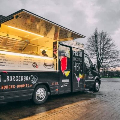 BurgerBox Foodtruck geparkt mit geöffnetem Verkaufsfenster und leuchtender Menütafel